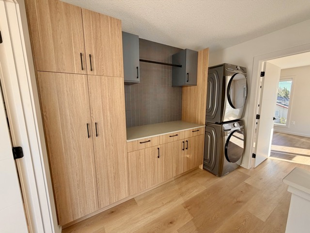 Upper-floor laundry with stacked washer, dryer and built-in storage